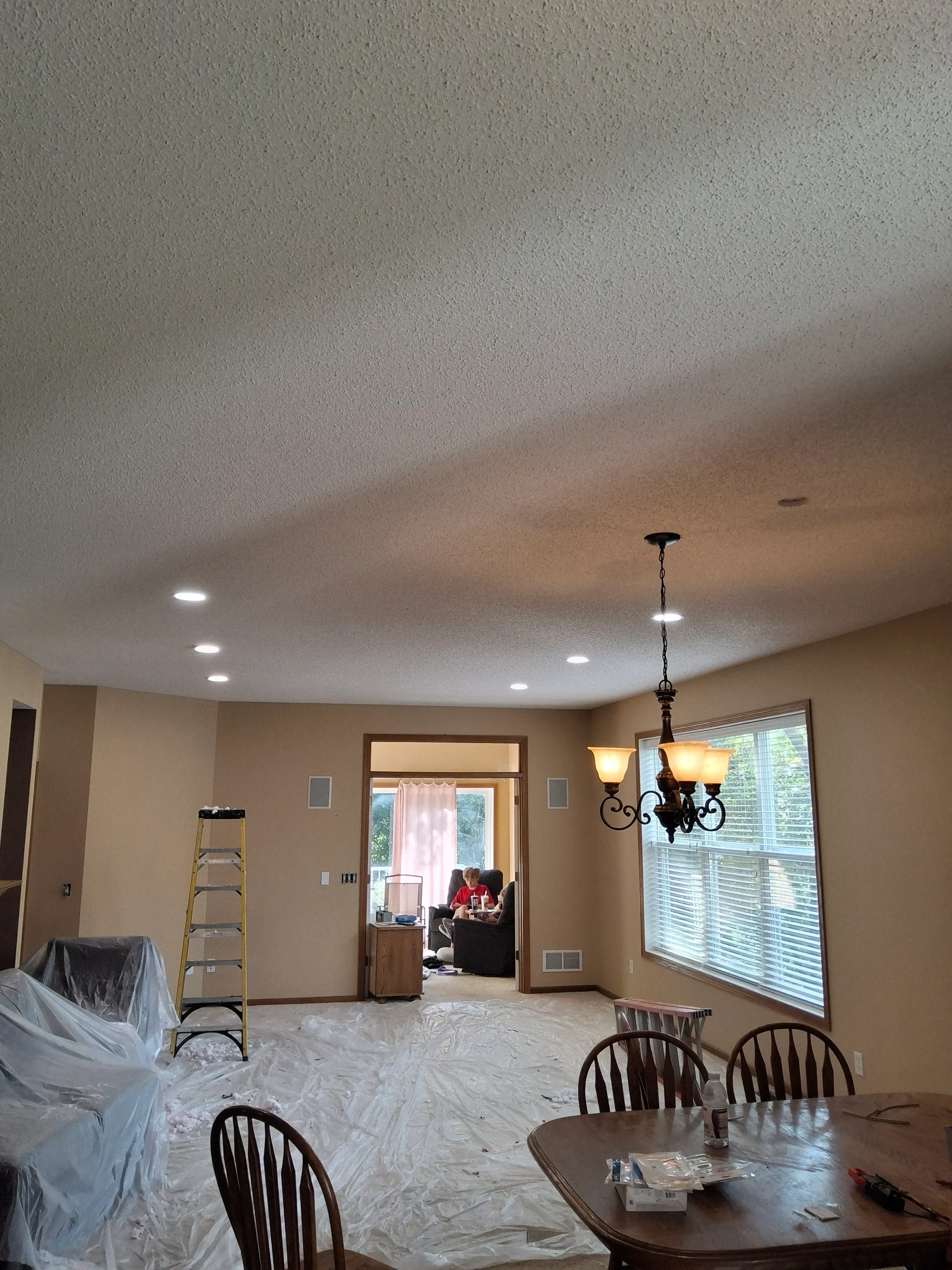 Recessed ceiling lights and pendant fixtures with amber glass shades, electrical outlets and wiring in residential interior