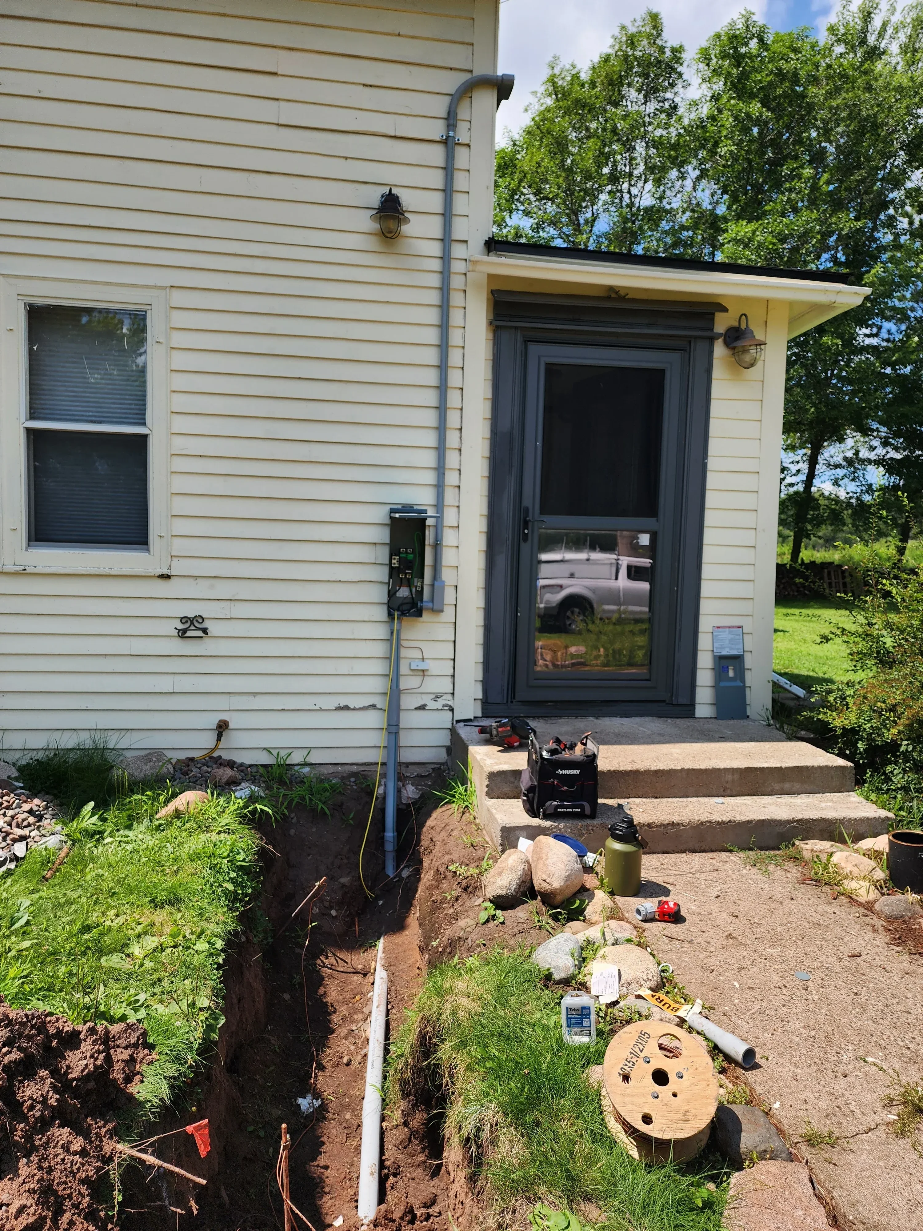 Electrical panel installation with conduit runs and wiring on residential construction project